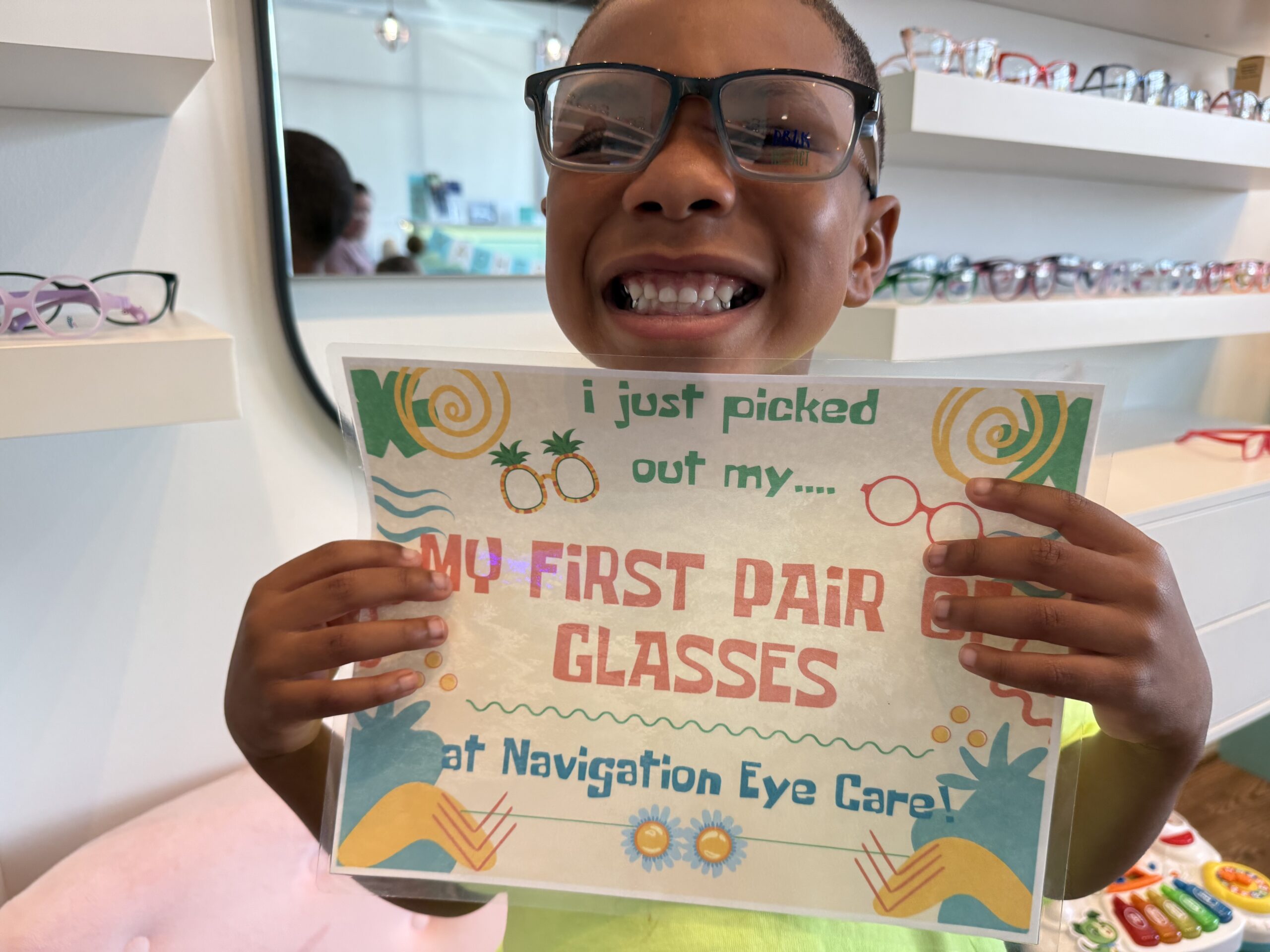 Child seen in Navigation Eye Care feeling proud for his first glasses for kids.