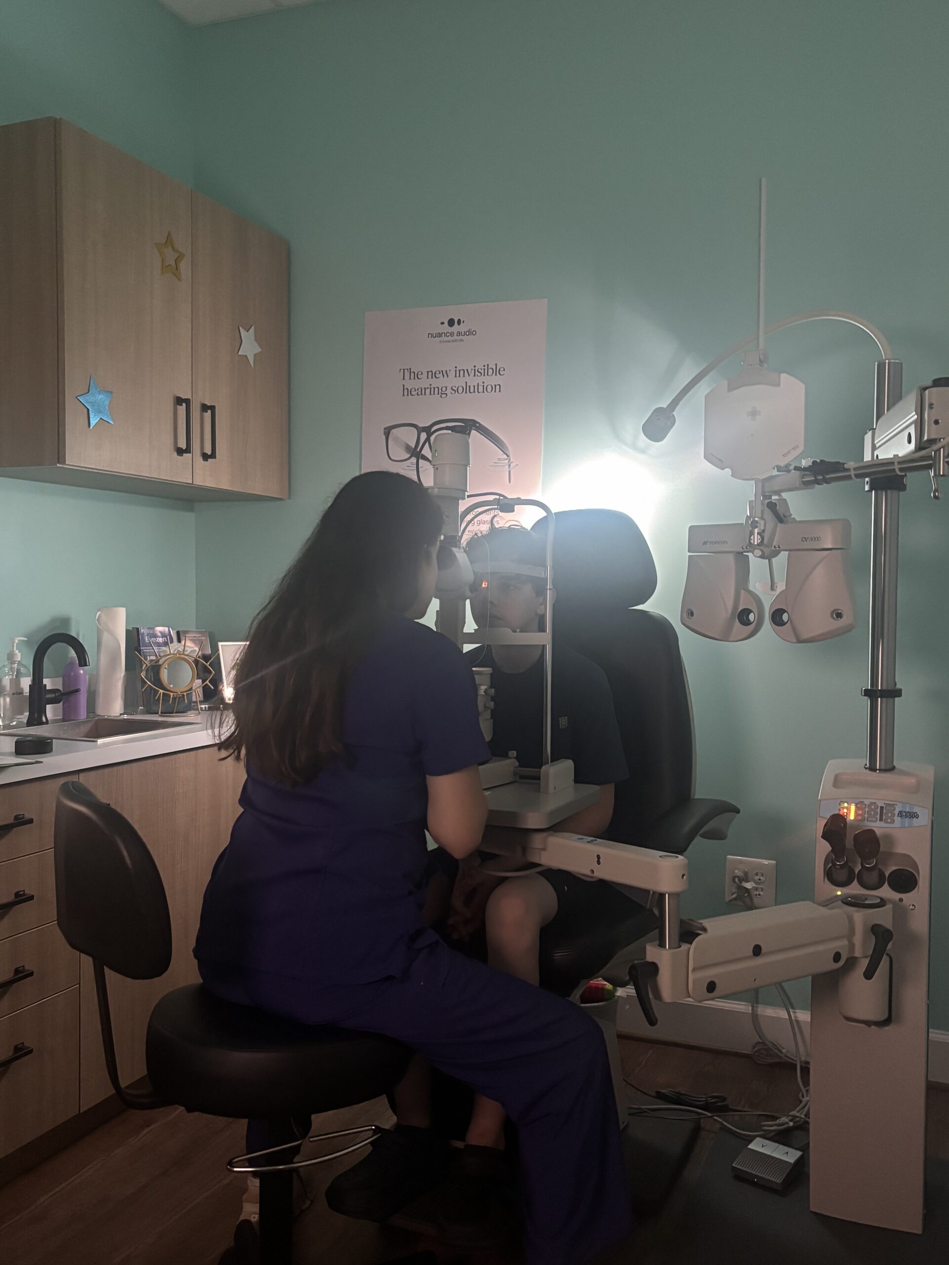 Child seen in Navigation Eye Care doing an eye exam with eye doctor to check genetics of myopia in children