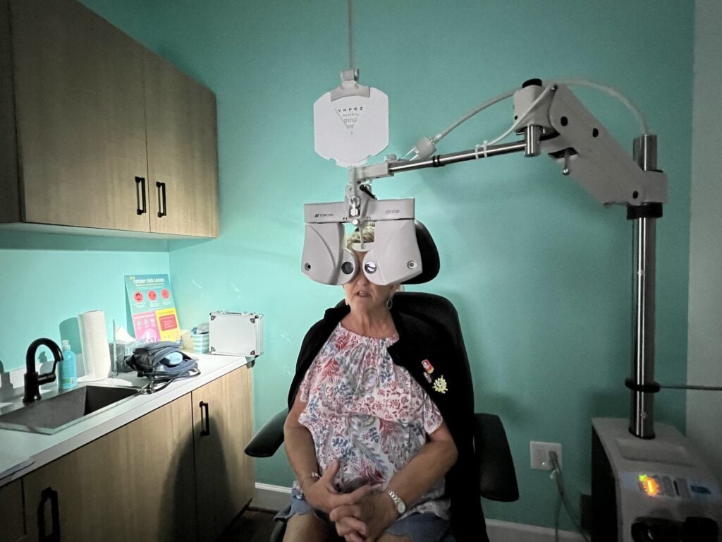 Patient receiving comprehensive eye exam with phoropter at Navigation Eye Care Chesapeake VA