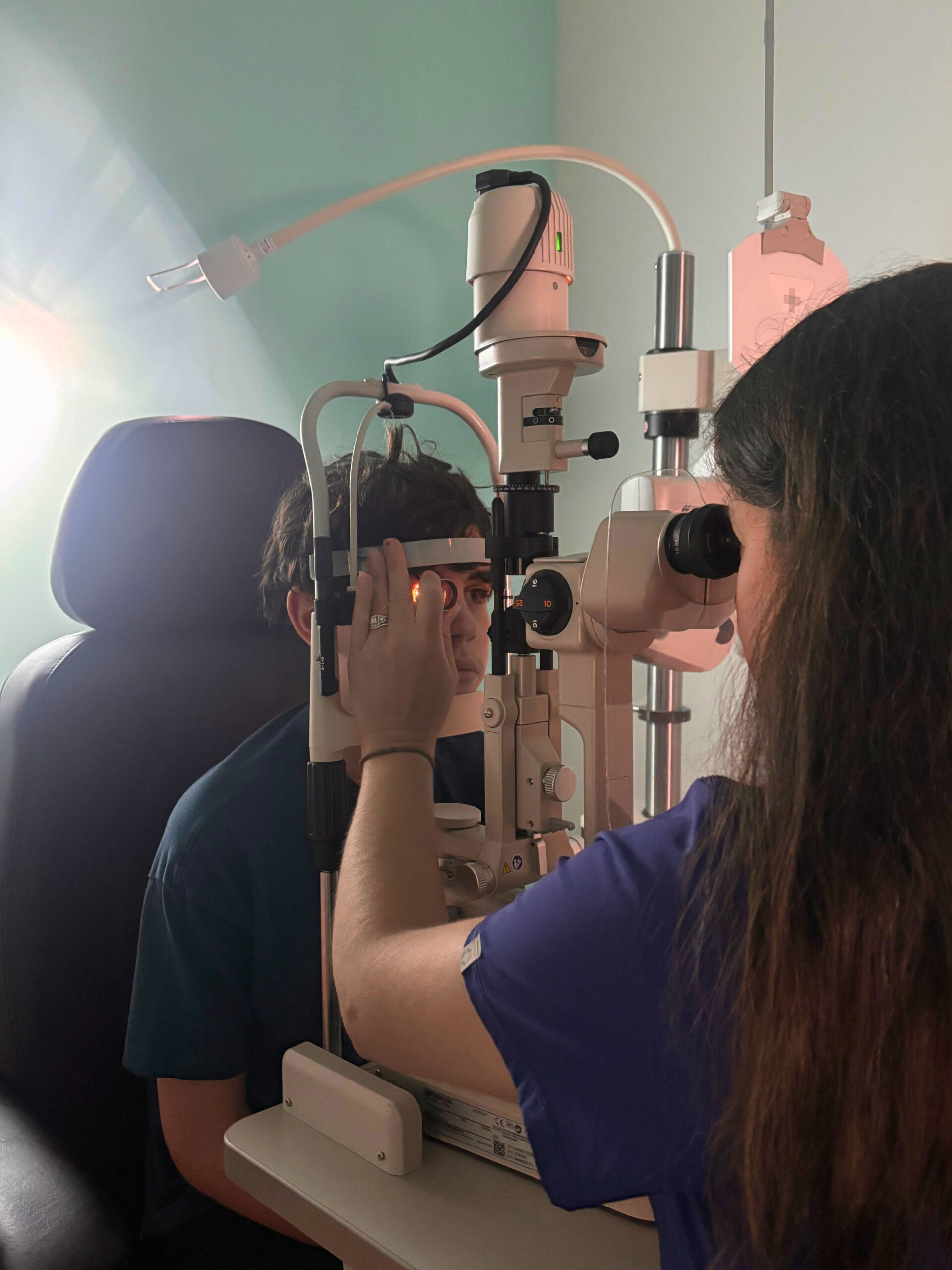 Kid seen in Navigation Eye Care with eye doctor for annual check up to avoid squinting eyes