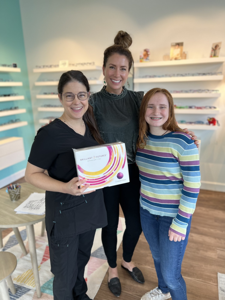 Navigation Eye Care team member with child wearing fun novelty glasses during visit at Chesapeake VA eye care practice