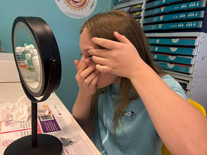 Child inserting MiSight daily contact lens for myopia management at Navigation Eye Care Chesapeake VA